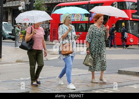 Londres, Royaume-Uni. 18 août 2023. Les femmes s'abritent sous des parapluies par temps humide dans le centre de Londres. (Photo Steve Taylor/SOPA Images/Sipa USA) crédit : SIPA USA/Alamy Live News Banque D'Images