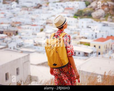 Nice Happy Female appréciant les îles grecques. Voyage en Grèce, îles méditerranéennes en dehors de la saison touristique. S'amuser à une vue imprenable sur la station balnéaire et la vieille ville de Lindos sur la montagne Banque D'Images