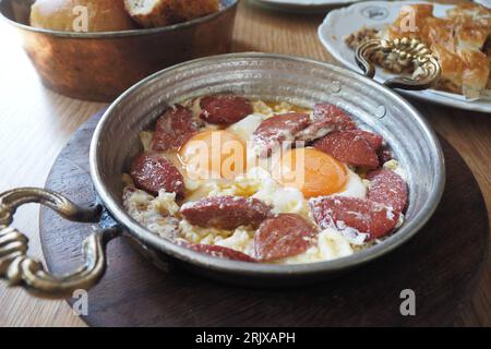 Turkish scrambled sausage eggs in copper pan Stock Photo