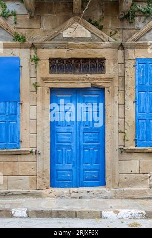 Belle demeure traditionnelle avec porte bleue lumineuse et fenêtres bleues, dans le village de Portianou sur l'île de Lemnos, au nord de la mer Égée, Grèce, Europe. Banque D'Images