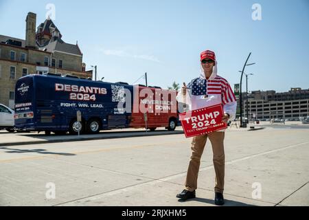 Milwaukee, USA. 23 août 2023. Un partisan de l'ancien président américain Donald Trump tient une pancarte devant le bus de campagne du gouverneur de Floride Ron Desantis devant le Fiserv Forum à Milwaukee, Wisconsin, le 23 août 2023, avant le premier débat présidentiel républicain. (Photo de Christopher Dilts/Sipa USA) crédit : SIPA USA/Alamy Live News Banque D'Images