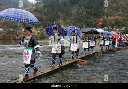 Bildnummer : 52449473 Datum : 09.03.2008 Copyright : imago/Xinhua Frauen aus der Volksgruppe der Dong überqueren einen Bach auf dem Weg zum Huapao-Fest in Rongshui - PUBLICATIONxNOTxINxCHN , Personen , ; 2008, Rongshui, Chine, Terre, Leute, Tradition, traditionelle Feste, Frühlingsfest, Chinois, Chinesen, Einheimische, folklore, Tracht, Trachten, ; , quer, Kbdig, totale, , Gesellschaft, Asien Banque D'Images