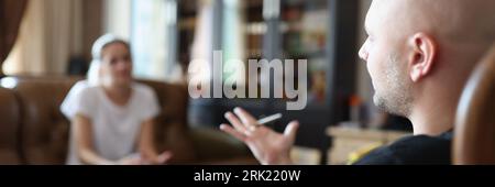 Le psychologue parle au patient tout en étant assis sur une chaise au bureau pendant la séance de psychothérapie. Banque D'Images