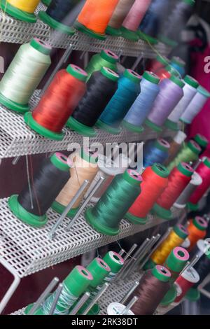 Colorful spools of thread on a rack close up view Stock Photo