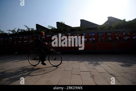 Bildnummer : 53378300 Datum : 18.09.2009 Copyright : imago/Xinhua (090918) -- PINGYAO, 18 septembre 2009 (Xinhua) -- un résident local passe devant des photos exposées à Pingyao, dans la province du Shanxi du nord de la Chine, le 18 septembre 2009. Le Festival international de photographie de Chine Pingyao 2009 débutera samedi. Pingyao, en tant que célèbre ville antique, est la seule ville ancienne avec le style Han en Chine classée au patrimoine culturel mondial. Initialement fondée dans la dynastie Zhou occidentale (1100 BC-771 BC), l'ancienne muraille de la ville de Pingyao avec près de 3 000 ans d'histoire, à l'heure actuelle, conserve essentiellement l'appe d'origine Banque D'Images