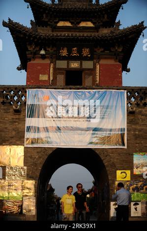 Bildnummer : 53378297 Datum : 18.09.2009 Copyright : imago/Xinhua (090918) -- PINGYAO, 18 septembre 2009 (Xinhua) -- les touristes passent devant une affiche du Festival international de photographie de Pingyao 2009 à Pingyao, province du Shanxi, dans le nord de la Chine, le 17 septembre 2009. Le Festival international de photographie de Chine Pingyao 2009 débutera samedi. Pingyao, en tant que célèbre ville antique, est la seule ville ancienne avec le style Han en Chine classée au patrimoine culturel mondial. Initialement fondée dans la dynastie Zhou occidentale (1100 BC-771 BC), l'ancienne muraille de la ville de Pingyao avec près de 3 000 ans d'histoire, à prese Banque D'Images