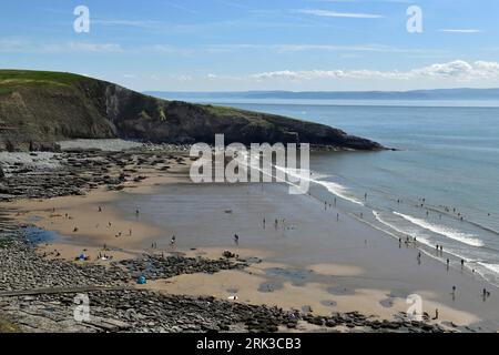 Regardant vers le bas sur la baie de Dunraven par un après-midi ensoleillé en juillet avec le Witches point clairement en vue ainsi que de nombreux fans de plage profitant de l'après-midi Banque D'Images