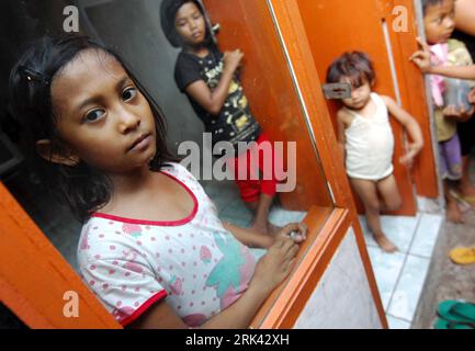 Bildnummer: 53580683  Datum: 25.10.2009  Copyright: imago/Xinhua (091105) -- JAKARTA, Nov. 5, 2009 (Xinhua) -- Indonesian girl Nurul, nine-year-old, stands outside the shanty of her family in a slum area in Jakarta Oct. 25, 2009. Four years ago, Nurul moved from Brebes, Central Java to northern Jakarta s slum area with her parents. Studying in the third grade at a nearby Muslim school, Nurul helps her parents wash clothes, clean the floor, look after her younger brother, and make some money with recycled items picked up from piles of garbage that surround the slum in the spare time. Life is ha Stock Photo