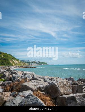 A scenic view of the rocky shoreline near the Steephill cove with buildings in the distance Stock Photo