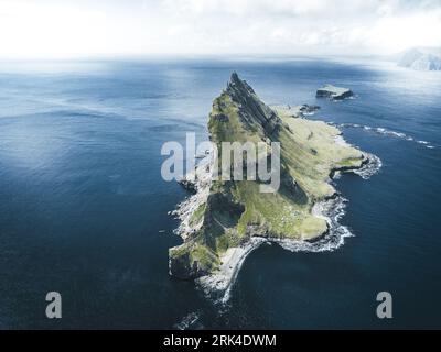 Prise de vue par drone de Drangarnir, les emblématiques cheminées marines nichées entre l’îlot de Tindholmur et l’île de Vagar dans les îles Féroé fascinantes. Banque D'Images