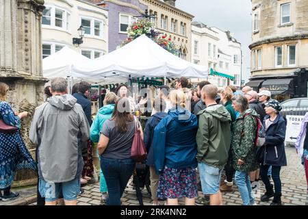 Touristes étant montré autour de Wells City Market Area, Wells, Somerset, Angleterre, Royaume-Uni. Banque D'Images