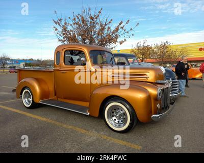 Une vieille camionnette Ford dorée des années 1940 dans un parking à un salon de voitures classiques Banque D'Images