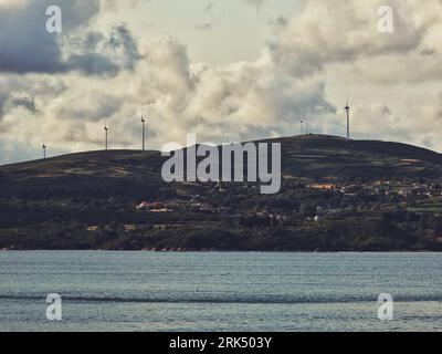 A scenic landscape featuring a mountain with several wind turbines in the background Banque D'Images