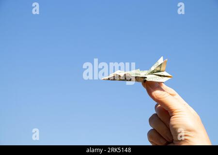 Avion d'un dollar dans la main d'une fille dans le ciel au-dessus de l'Ukraine, la liberté et la vie Banque D'Images