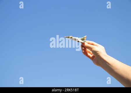 Avion d'un dollar dans la main d'une fille dans le ciel au-dessus de l'Ukraine, la liberté et la vie Banque D'Images