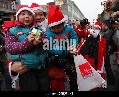 Bildnummer : 53687048 Datum : 24.12.2009 Copyright : imago/Xinhua (091225) -- LUOYANG, 25 décembre 2009 (Xinhua) -- Un fan de photographie déguisé en Père Noël pose pour des photos avec deux garçons qui reçoivent des cadeaux de Noël de lui lors d'une activité photographique à Luoyang, dans la province du Henan centrale de la Chine, le 24 décembre 2009. Environ 50 fans de photographie déguisés en Père Noël ont pris part à une activité de photographie dans la vieille ville de Luoyang la veille de Noël, au cours de laquelle ils ont distribué des bonbons et des stationeries aux enfants. (Xinhua/Zhang Xiaoli) (Ly) (1)CHINA-HENAN-LUOYANG-PHOTOGRAPHY FAN-CHRISTMAS (CN) PUBLICATIONxN Banque D'Images
