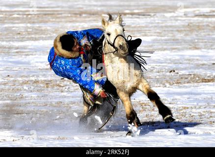 Bildnummer: 53688641  Datum: 28.12.2009  Copyright: imago/Xinhua (091228) -- XI UJIMQIN QI (INNER MONGOLIA), Dec. 28, 2009 (Xinhua) -- A herdsman tries to pick a thing on a running horse in Xi Ujimqin Qi, north China s Inner Mongolia Autonomous Region, on Dec. 28, 2009. Ujimqin grassland ice and snow carnival is opened here on Monday, with many activities including horse-racing, archery, picking things on a running horse and camel-racing, attracting tourists here to taste the unique custom of Mongolian ethnic group. (Xinhua/Ren Junchuan) (lr) (1)CHINA-INNER MONGOLIA-XI UJIMQIN QI-ICE AND SNOW Stock Photo