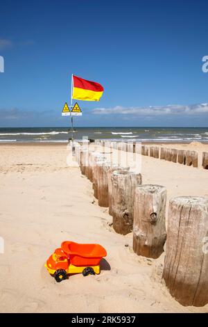 Drapeau et panneaux avertissent les nageurs de groynes dans l'eau, camion jouet, la plage de Domburg sur la péninsule Walcheren, Zélande, pays-Bas. Flagge und Sch Banque D'Images