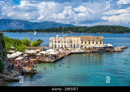 Vue vers le bas sur la plage de baignade Faliraki et restaurant dans la vieille ville de Corfou, île de Corfou, îles Ioniennes, Grèce Banque D'Images