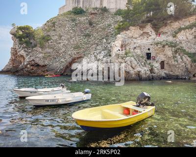 Une scène paisible de plusieurs petits bateaux flottant sur un plan d'eau vitreux à Dubrovnik, Croatie Banque D'Images