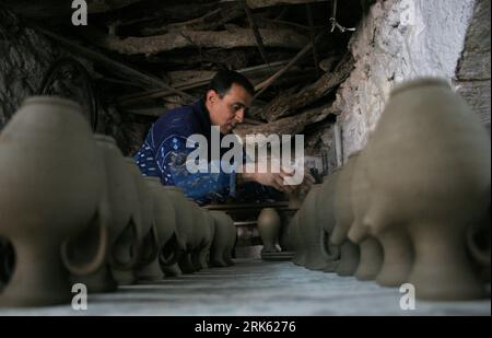 Bildnummer: 53783914  Datum: 07.02.2010  Copyright: imago/Xinhua (100208)-- JENIN, Feb. 8, 2010 (Xinhua) -- A Palestinian pottery worker shapes clay to make earthenware pots at his traditional mill in Jaba village, southern the West Bank city of Jenin on Feb. 7, 2010. Pottery is a very ancient and traditional industry in the small northern west bank village of Japa, which is rich in fine-quality clay, residents say. (Xinhua/Ayman Nobani)(dyw) (1)PALESTINE-JENIN-POTTERY PUBLICATIONxNOTxINxCHN Gesellschaft Arbeitswelten  Produktion kbdig xub 2010 quer o0 Handwerk, Töpfer, Töpfern    Bildnummer 5 Stock Photo