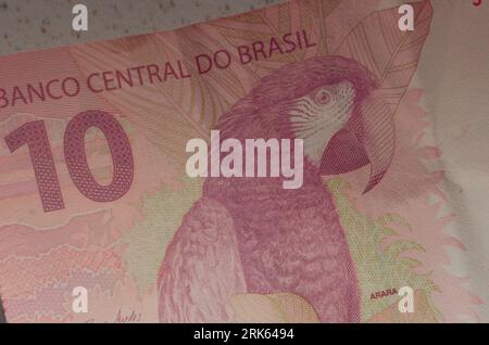 Détail du billet de banque de 10 reais do Brasil, une monnaie brésilienne mise en valeur par sa couleur rouge emblématique. Casa da Moeda do Brasil, représentant le B. Banque D'Images