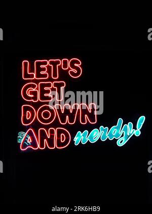 Un panneau néon de librairie « let's get down and Nerdy » aux lumières bleues et rouges Banque D'Images