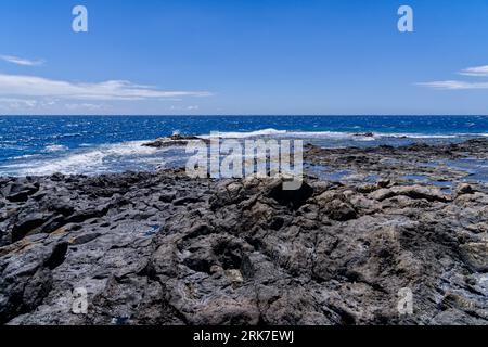 Une vue panoramique sur une plage rocheuse contre les vagues de la mer Banque D'Images