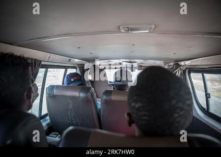 Personnes vues voyageant en minibus de Tunis à la ville côtière tunisienne de Sfax. La Tunisie est devenue le premier pays de départ pour les personnes qui tentent de rejoindre l’Europe en traversant la mer Méditerranée sur la route migratoire dite de la Méditerranée centrale, que l’ONU a qualifiée de la plus meurtrière au monde. Banque D'Images