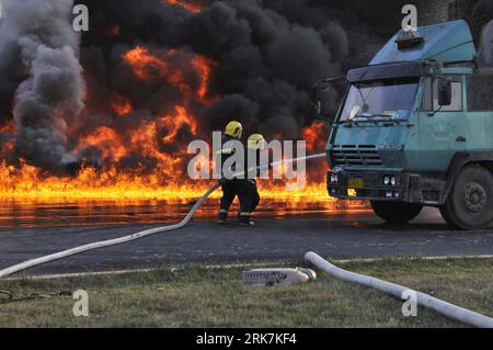 Bildnummer: 53923764  Datum: 07.04.2010  Copyright: imago/Xinhua (100407) -- TIANJIN, April 7, 2010 (Xinhua) -- Firemen spray water to put out a fire at the site of a traffic accident in Tianjin, north China, April 7, 2010. Three trucks including an oil tank collided early Wednesday in Tianjin, causing a blaze, which took local fire department more than three hours to put out. A driver was injured in the accident. (Xinhua/Zhao Wei) (wqq) CHINA-TIANJIN-COLLISION-FIRE (CN) PUBLICATIONxNOTxINxCHN Strasse Verkehr Unfall Verkehrsunfall kbdig xsk 2010 quer o0 Lkw Wrack Feuerwehr Löscharbeiten Feuer Stock Photo