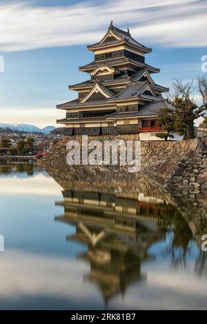 Une longue exposition du château de Matsumoto au Japon se reflétant dans ses douves en fin d'après-midi. Banque D'Images