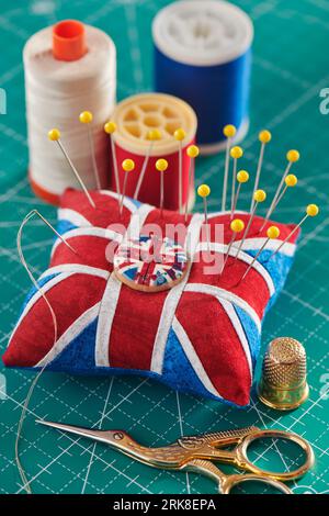 Coussinet comme Union Jack sur tapis d'artisanat vert, accessoires de couture Banque D'Images