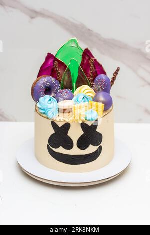 Gâteau inspiré de la guimauve pop. Décoré avec des beignets, sucettes et macarons sur fond neutre Banque D'Images