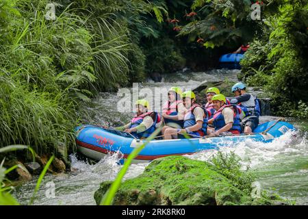 Pangalengan, Bandung-Indonésie décembre 2022 : Un groupe d'hommes et de femmes font du rafting sur la rivière, du sport extrême et amusant. Groupe de personnes sport nautique r Banque D'Images