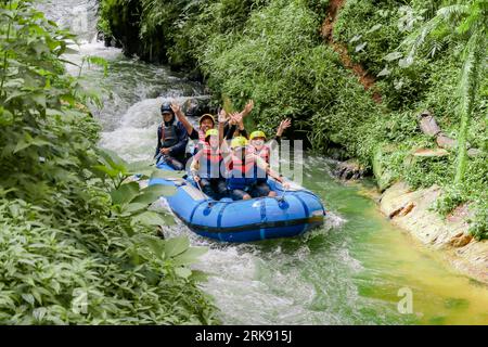 Pangalengan, Bandung-Indonésie décembre 2022 : Un groupe d'hommes et de femmes font du rafting sur la rivière, du sport extrême et amusant. Groupe de personnes sport nautique r Banque D'Images