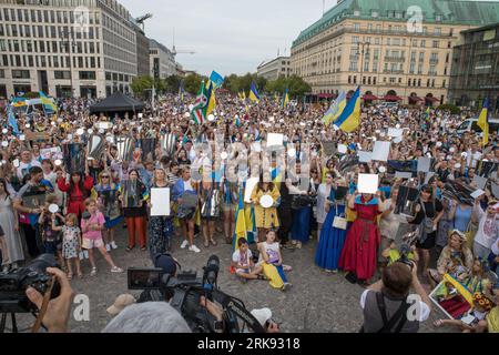 Les Ukrainiens se sont réunis à la porte de Brandebourg à Berlin le 24 août 2023 pour marquer le jour de l'indépendance de l'Ukraine. Mais ce n'était pas une célébration ordinaire. La foule, une mer de tournesols, de drapeaux, de bannières et de vêtements ukrainiens traditionnels, est venue avec un message de souvenir et de résilience. Dans un geste symbolique, les participants ont brandi des miroirs, 503 au total, chacun reflétant le visage d'un enfant perdu dans la guerre de la Russie contre l'Ukraine. Scintillant sous le soleil couchant, les miroirs ont servi de rappel obsédant aux 503 enfants ukrainiens dont la vie a été abruptement et impitoyablement prise dans le conflit. «Ukrainien Banque D'Images