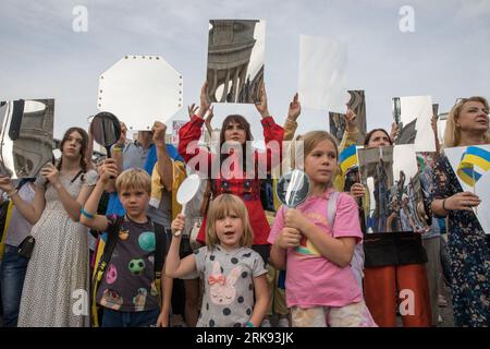 Les Ukrainiens se sont réunis à la porte de Brandebourg à Berlin le 24 août 2023 pour marquer le jour de l'indépendance de l'Ukraine. Mais ce n'était pas une célébration ordinaire. La foule, une mer de tournesols, de drapeaux, de bannières et de vêtements ukrainiens traditionnels, est venue avec un message de souvenir et de résilience. Dans un geste symbolique, les participants ont brandi des miroirs, 503 au total, chacun reflétant le visage d'un enfant perdu dans la guerre de la Russie contre l'Ukraine. Scintillant sous le soleil couchant, les miroirs ont servi de rappel obsédant aux 503 enfants ukrainiens dont la vie a été abruptement et impitoyablement prise dans le conflit. «Ukrainien Banque D'Images