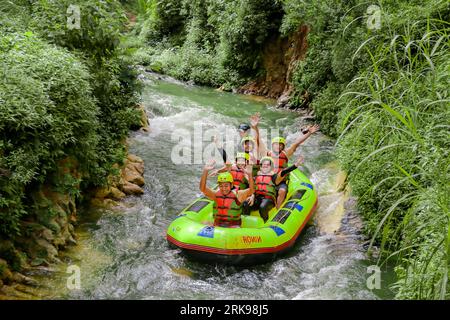 Pangalengan, Bandung-Indonésie décembre 2022 : Un groupe d'hommes et de femmes font du rafting sur la rivière, du sport extrême et amusant. Groupe de personnes sport nautique r Banque D'Images