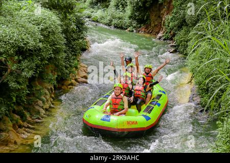 Pangalengan, Bandung-Indonésie décembre 2022 : Un groupe d'hommes et de femmes font du rafting sur la rivière, du sport extrême et amusant. Groupe de personnes sport nautique r Banque D'Images