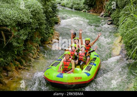 Pangalengan, Bandung-Indonésie décembre 2022 : Un groupe d'hommes et de femmes font du rafting sur la rivière, du sport extrême et amusant. Groupe de personnes sport nautique r Banque D'Images