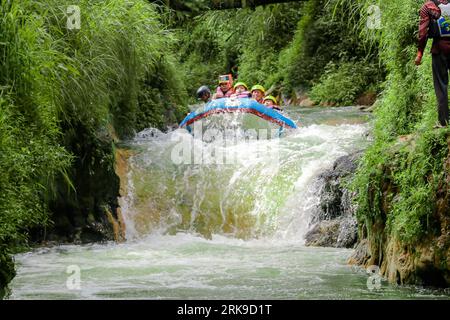 Pangalengan, Bandung-Indonésie décembre 2022 : Un groupe d'hommes et de femmes font du rafting sur la rivière, du sport extrême et amusant. Groupe de personnes sport nautique r Banque D'Images