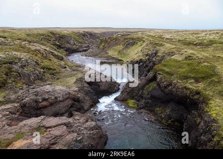 Paysage fantastique avec des rivières qui coulent et des ruisseaux avec des rochers et de l'herbe en Islande Banque D'Images