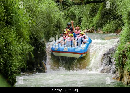 Pangalengan, Bandung-Indonésie décembre 2022 : Un groupe d'hommes et de femmes font du rafting sur la rivière, du sport extrême et amusant. Groupe de personnes sport nautique r Banque D'Images