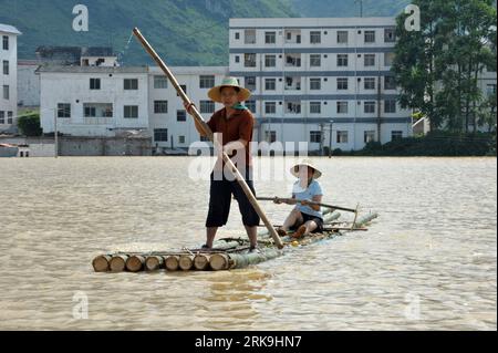 Bildnummer: 54198896  Datum: 02.07.2010  Copyright: imago/Xinhua (100702) -- LINGYUN(GUANGXI), July 2, 2010 (Xinhua) -- Local residents row a bamboo raft in flood water at Shali Village of Yao ethnic group in Lingyun County, southwest China s Guangxi Zhuang Autonomous Region, July 2, 2010. Torrential rainstorms ravaged Shali Village from June 27 to June 30, causing serious flood which cut off electricity, traffics and clean water supplies there. A total of 3700 mu (about 244.87 hectares) farmland had been destroyed by the flood. (Xinhua/Zhou Hua) (lyx) (7)CHINA-GUANGXI-LINGYUN-FLOOD (CN) PUBLI Stock Photo