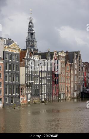 Bâtiments de la ville d'Amsterdam le long des canaux aux Pays-Bas, avec des façades colorées, des pignons historiques et des maisons de ville néerlandaises classiques. Banque D'Images