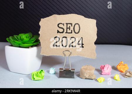 Sur la loupe sont des bandes de papier avec l'inscription - SEO 2024 Banque D'Images