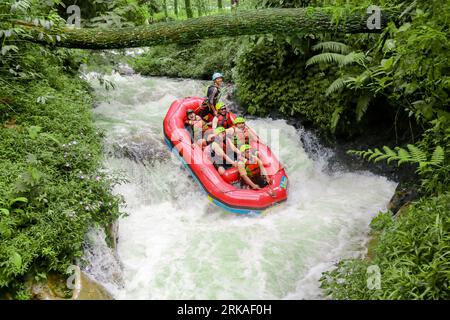 Pangalengan, Bandung-Indonésie décembre 2022 : Un groupe d'hommes et de femmes font du rafting sur la rivière, du sport extrême et amusant. Groupe de personnes sport nautique r Banque D'Images