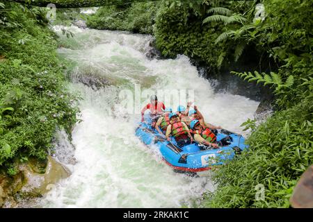 Pangalengan, Bandung-Indonésie décembre 2022 : Un groupe d'hommes et de femmes font du rafting sur la rivière, du sport extrême et amusant. Groupe de personnes sport nautique r Banque D'Images