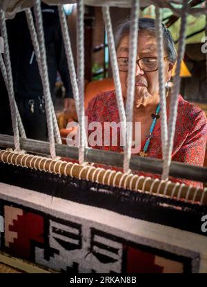 Une femme Navajo tisse un tapis dans le hall de l'hôtel El Rancho à Gallup, NOUVEAU-MEXIQUE Banque D'Images