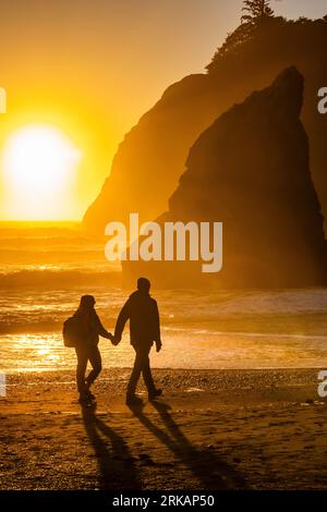 Couple profitant d'une promenade au coucher du soleil sur Ruby Beach, parc national olympique, État de Washington, États-Unis [aucune autorisation du modèle ; licence éditoriale uniquement] Banque D'Images